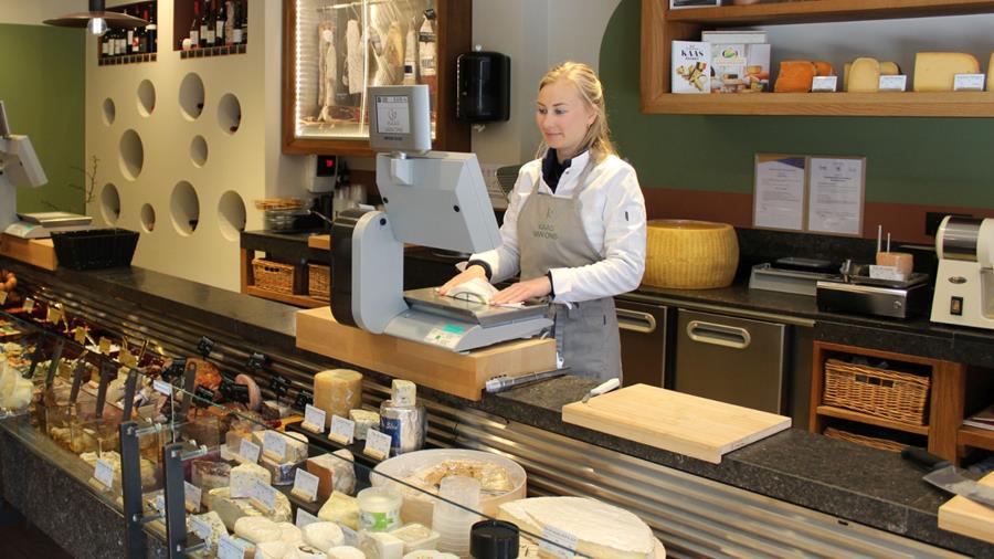 Jeune maître fromagère avec son propre magasin